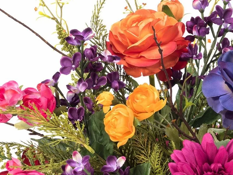 Close-up of orange and gold silk ranunculus with purple lilac