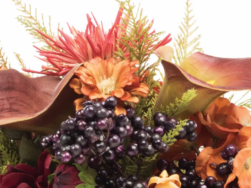 Close-up of deep purple silk blackberries beneath a cinnamon brown calla lily