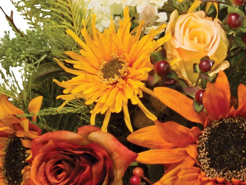 Close-up of silk roses, yellow mums and a white hydrangea with berries and fern