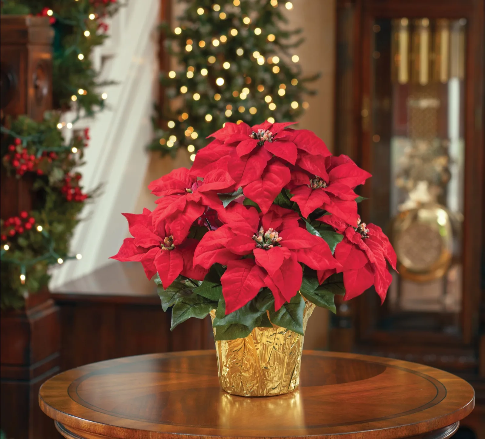 Table Top Silk Poinsettia Plant on an entry table beside a decorated staircase