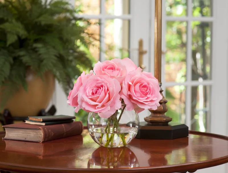 Pink Rose Nosegay silk flower arrangement on a round wood side table by a window