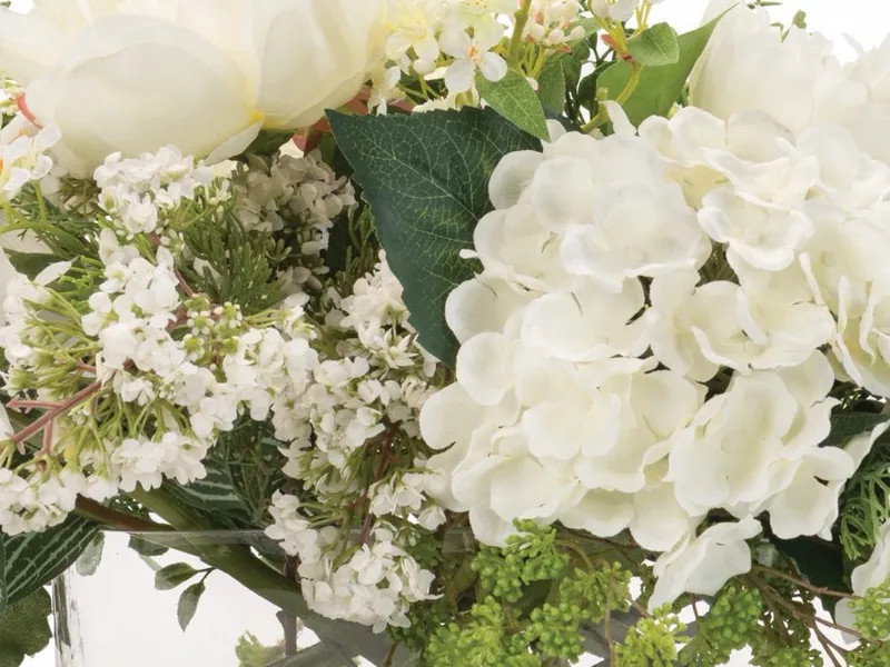 Close-up of a white silk hydrangea head with sprays of lilac