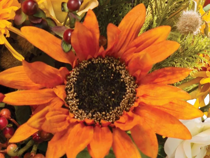 Macro close-up of a silk sunflower showing the seeded center and petal shading