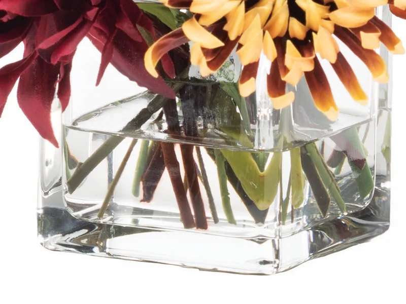 Four inch glass cube vase filled with crystal-clear acrylic water around the stems