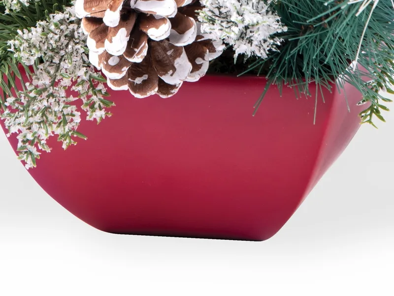 The red square resin planter, tapered, holding the frosted greenery and a cone