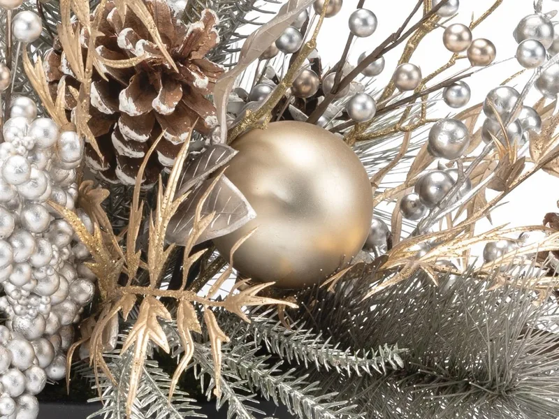 Macro close-up of a matte champagne gold ornament with silver berry sprays