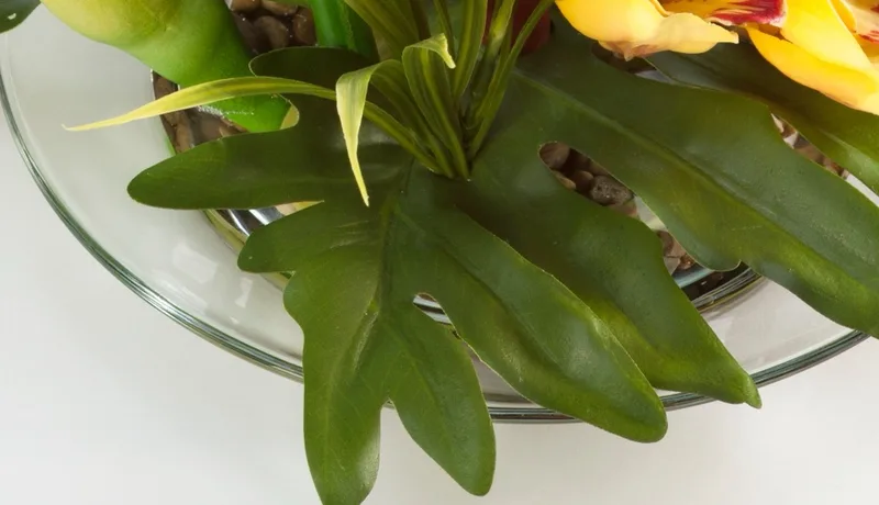 Glass bowl with natural pebbles and clear acrylic water at the base of the arrangement